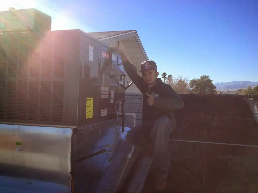 HVAC technician performing AC Tune-Up on a rooftop unit in Baton Rouge